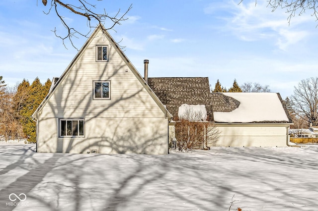 snow covered property featuring brick siding