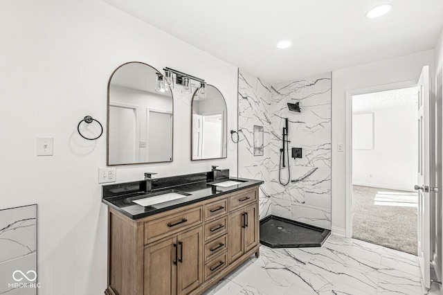 bathroom with double vanity, marble finish floor, a marble finish shower, and a sink