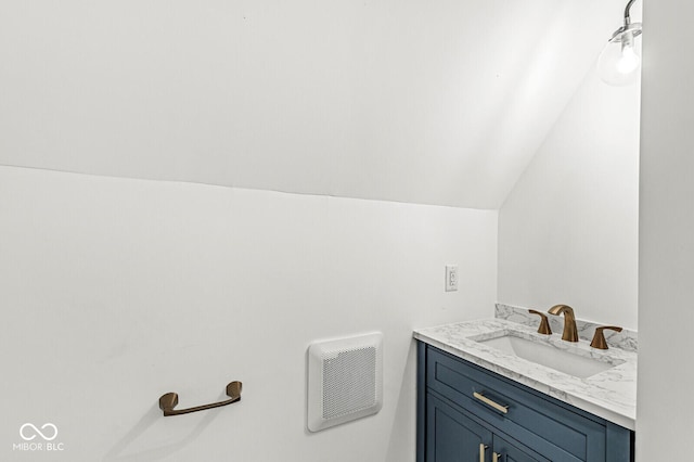 bathroom with vanity, lofted ceiling, and visible vents