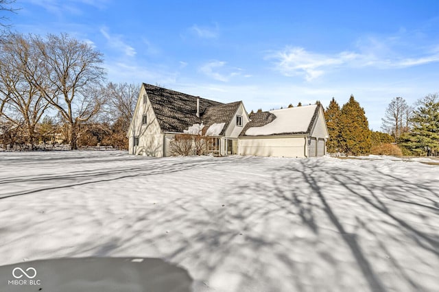 snow covered property featuring a garage