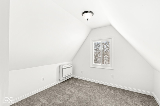 bonus room featuring vaulted ceiling, heating unit, baseboards, and dark carpet