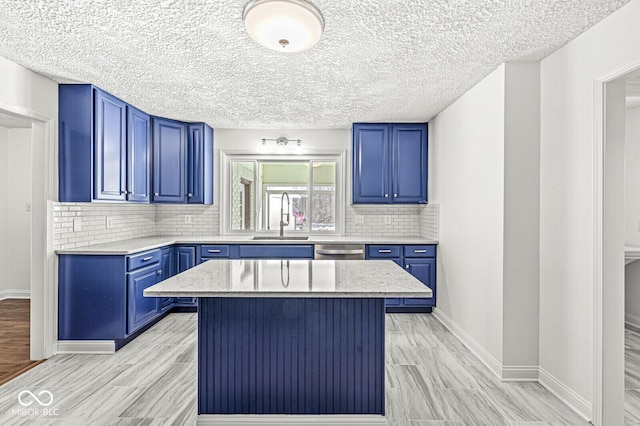 kitchen featuring blue cabinets, a sink, backsplash, a kitchen island, and stainless steel dishwasher