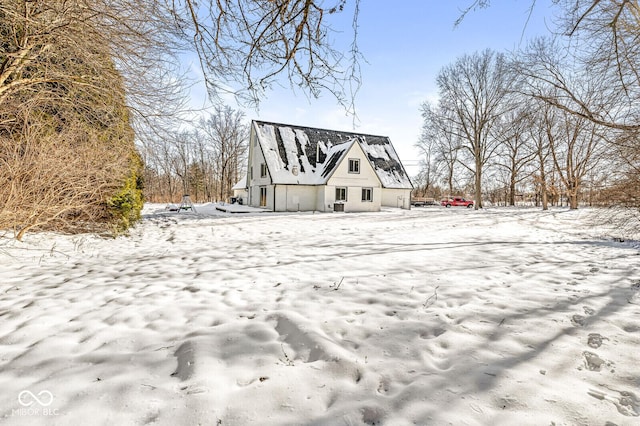 snow covered house featuring a barn