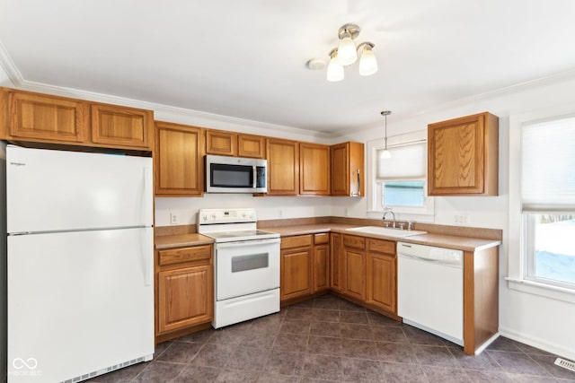 kitchen featuring a wealth of natural light, sink, white appliances, and pendant lighting