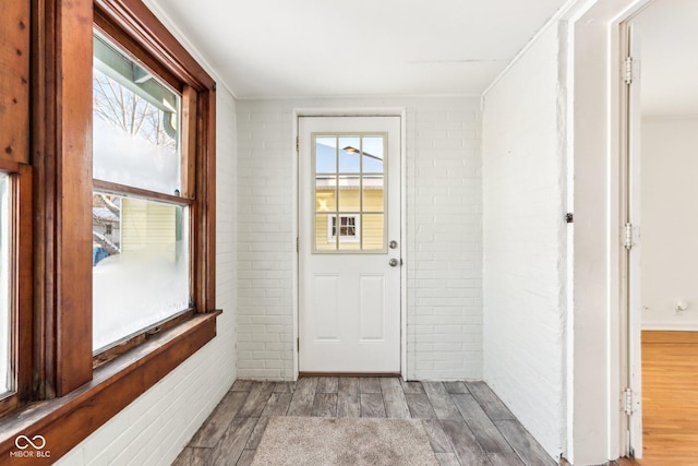 entryway featuring brick wall and light hardwood / wood-style flooring