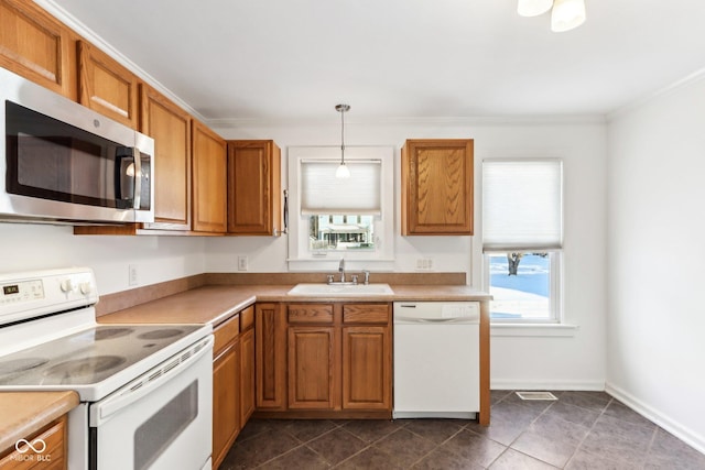 kitchen with crown molding, sink, hanging light fixtures, and white appliances