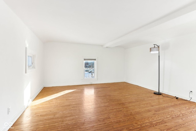 unfurnished room featuring beam ceiling and light hardwood / wood-style flooring