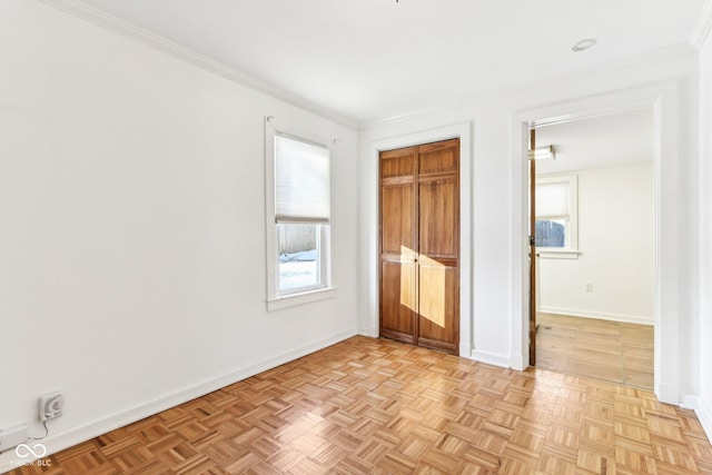 unfurnished bedroom featuring light parquet flooring and crown molding