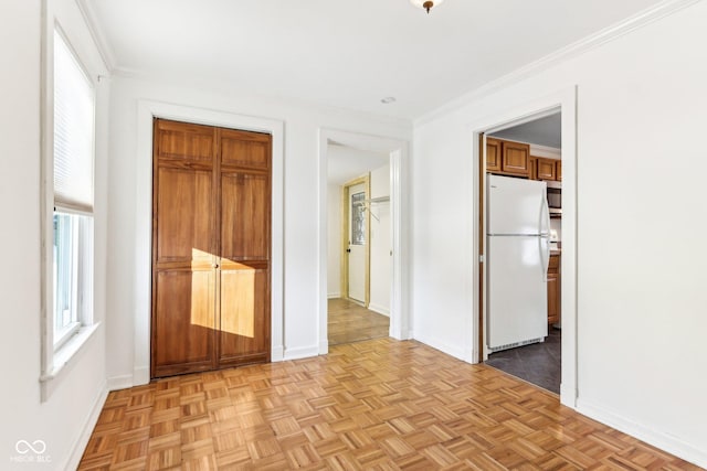 unfurnished bedroom with light parquet floors, a closet, crown molding, and white fridge