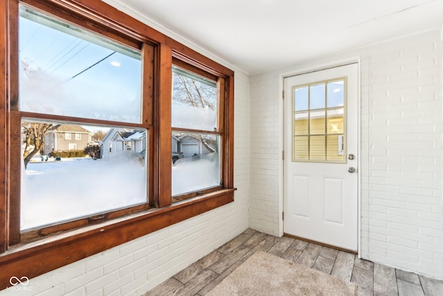 doorway featuring brick wall