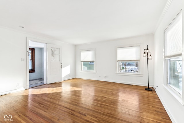 empty room featuring ornamental molding and light hardwood / wood-style flooring