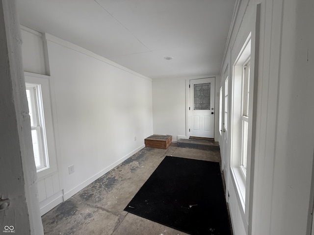 entrance foyer featuring ornamental molding and a healthy amount of sunlight