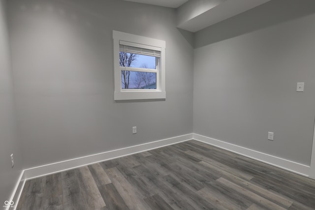 unfurnished room with dark wood-type flooring