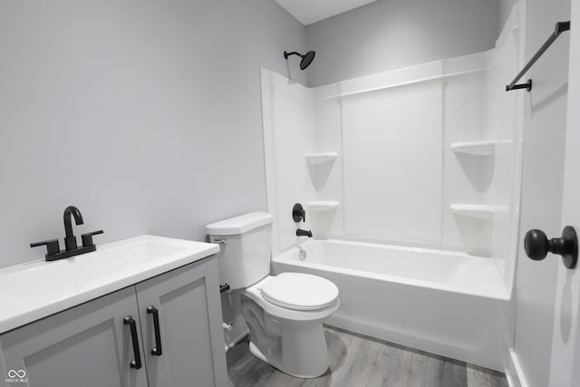 full bathroom featuring hardwood / wood-style flooring, vanity, shower / tub combination, and toilet