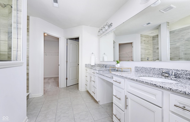 bathroom featuring tile patterned floors, a shower, and vanity