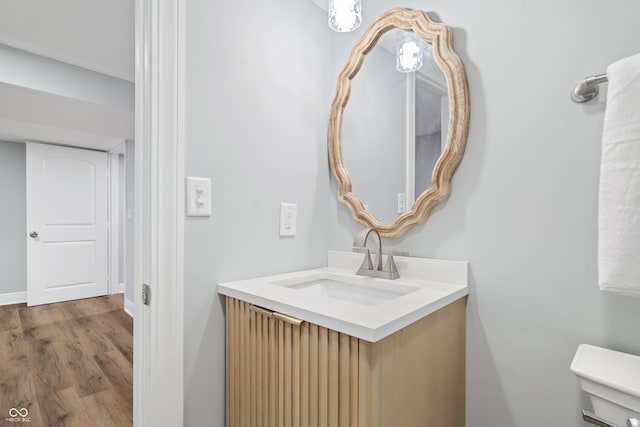 bathroom with vanity, toilet, and hardwood / wood-style floors