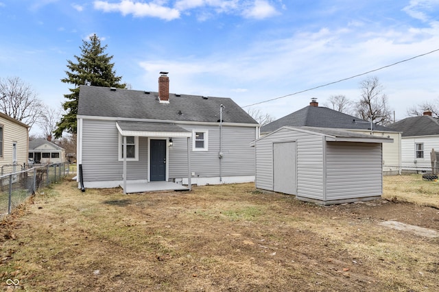 rear view of house with a storage shed and a yard