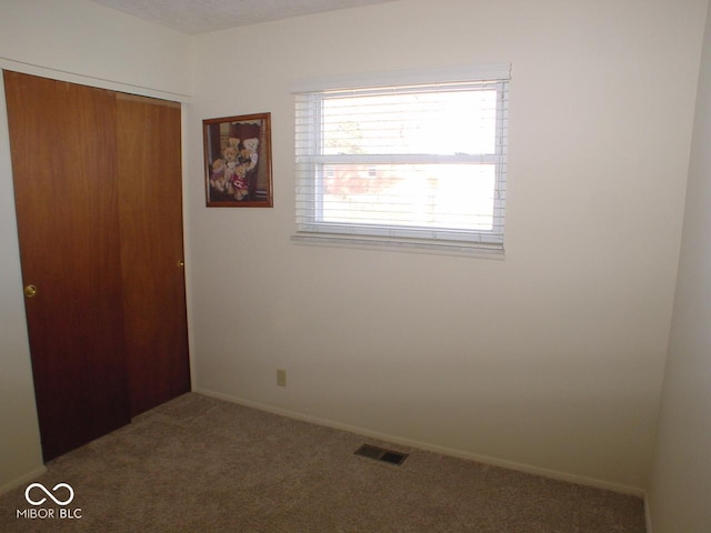 unfurnished bedroom with a closet and carpet flooring