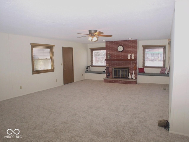 unfurnished living room featuring ceiling fan, carpet flooring, and a fireplace