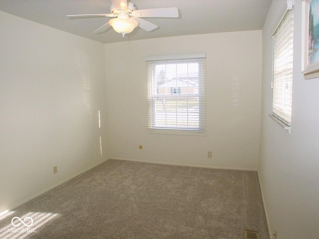 empty room featuring carpet floors and ceiling fan