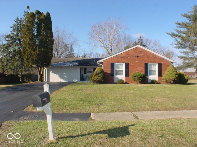 ranch-style house featuring a garage and a front lawn