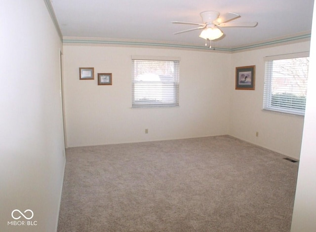 carpeted empty room featuring ceiling fan and crown molding