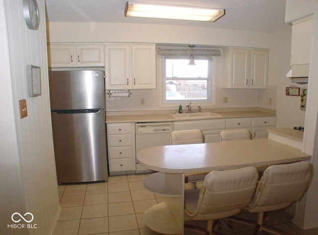 kitchen with sink, backsplash, stainless steel fridge, white dishwasher, and light tile patterned floors