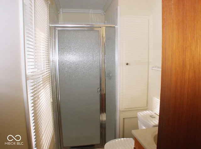 bathroom with ornamental molding, a shower with shower door, and vanity