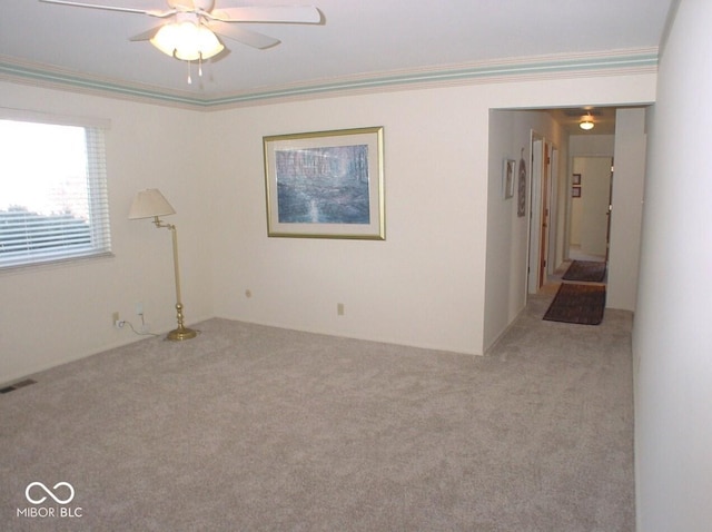 unfurnished room featuring ceiling fan, ornamental molding, and light colored carpet