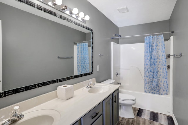 full bathroom with shower / tub combo, vanity, hardwood / wood-style flooring, and toilet