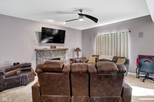 carpeted living room with ceiling fan and a fireplace