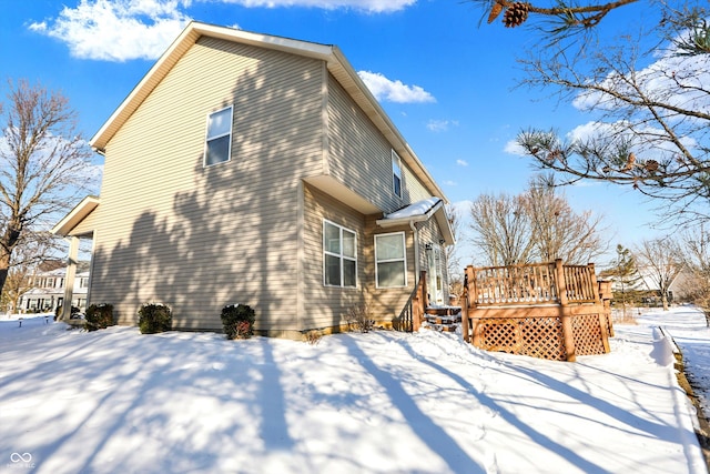 view of snowy exterior featuring a deck