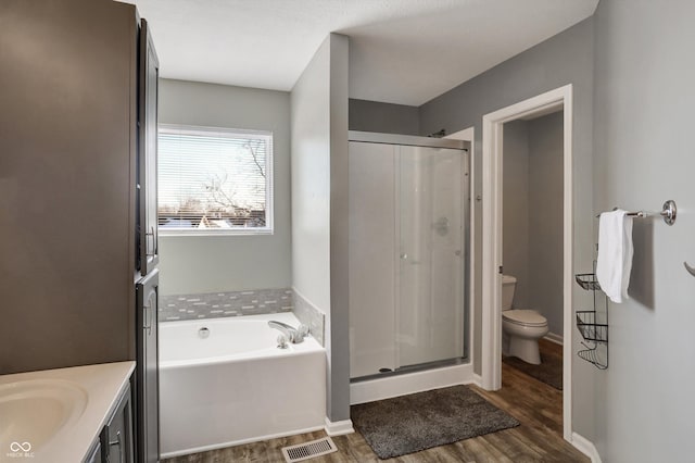 full bathroom with vanity, toilet, independent shower and bath, and hardwood / wood-style floors