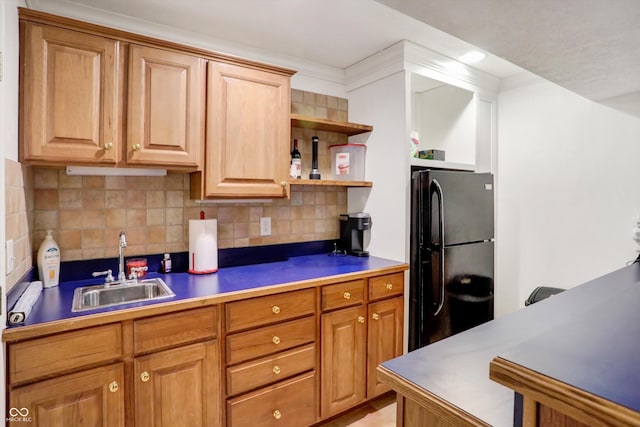 kitchen with black fridge, sink, and backsplash