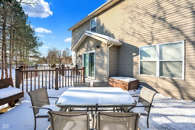 snow covered patio with a deck