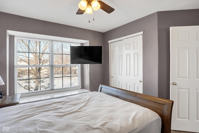 bedroom featuring multiple windows, a closet, and ceiling fan