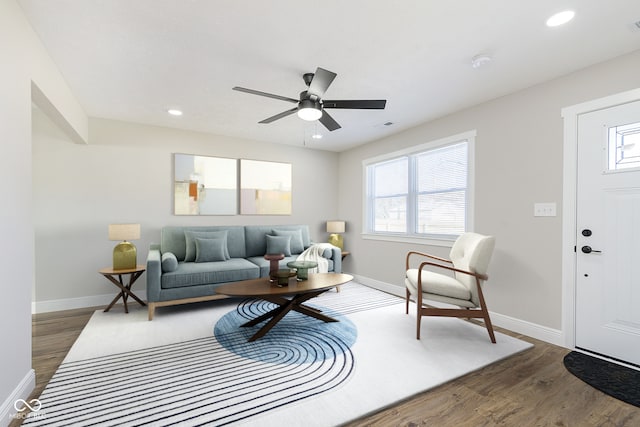 living room with dark hardwood / wood-style floors and ceiling fan