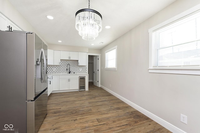 kitchen with white cabinetry, beverage cooler, an inviting chandelier, stainless steel refrigerator with ice dispenser, and backsplash