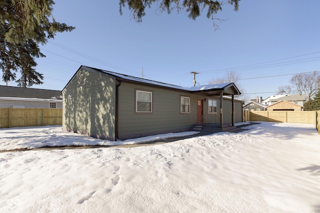 view of snow covered rear of property