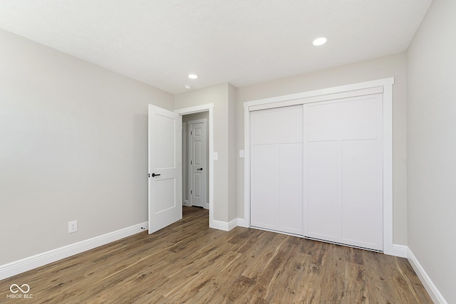 unfurnished bedroom with hardwood / wood-style floors and a closet