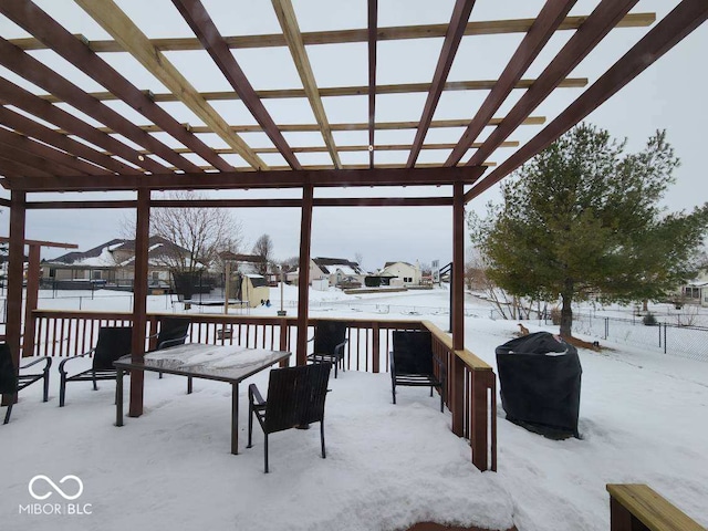 snow covered deck with a pergola and area for grilling