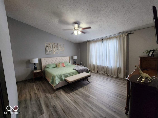 bedroom featuring hardwood / wood-style floors, a textured ceiling, ceiling fan, and lofted ceiling