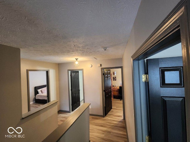 hallway featuring a textured ceiling and light wood-type flooring