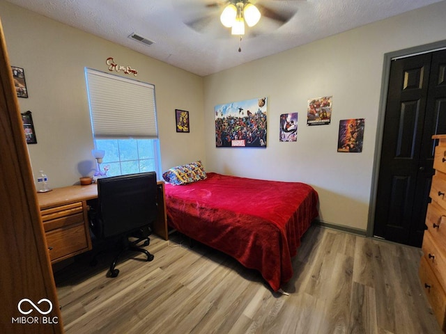 bedroom with ceiling fan, a textured ceiling, and hardwood / wood-style flooring