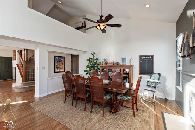 dining space with high vaulted ceiling, ceiling fan, and hardwood / wood-style floors