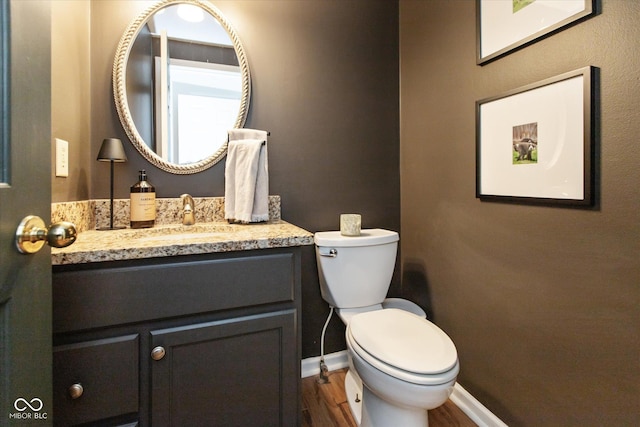 bathroom with hardwood / wood-style floors, vanity, and toilet