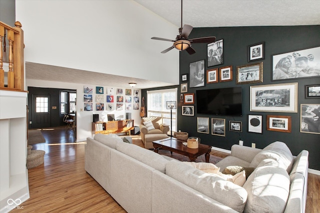 living room with wood-type flooring, high vaulted ceiling, and ceiling fan