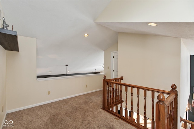 corridor with lofted ceiling and carpet