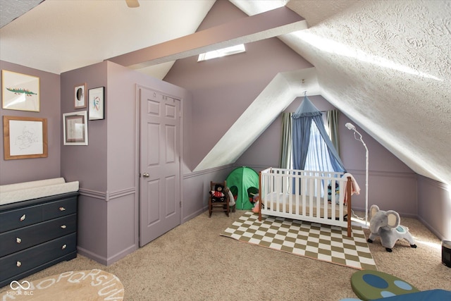 carpeted bedroom featuring lofted ceiling, a textured ceiling, and a crib