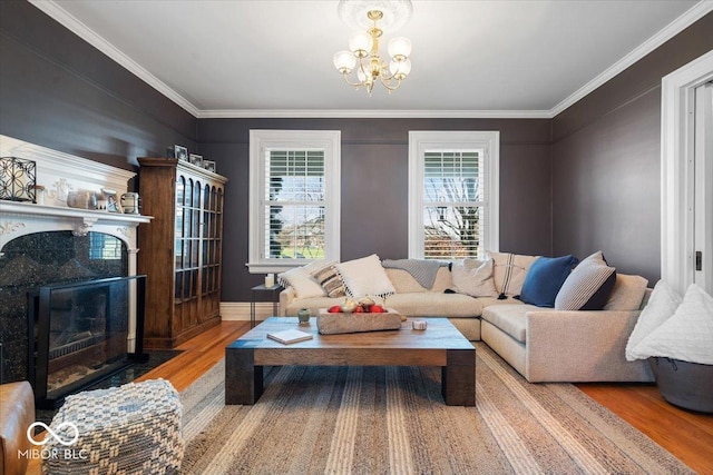 living room with hardwood / wood-style flooring, a premium fireplace, ornamental molding, and a chandelier